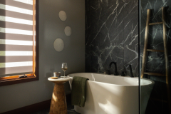 Luxurious bathroom with a deep soaking tub set against a stunning dark marble wall.